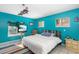 Bright blue bedroom with tiled floors, vintage ceiling fan, and plenty of natural light at 327 Hernando Ave, Sarasota, FL 34243