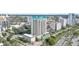 Aerial view showcasing a luxury high-rise condo with palm trees, and city streets at 340 S Palm Ave # Pl1, Sarasota, FL 34236