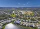 An aerial view of a lakeside home in a golf community with well-maintained landscaping and beautiful blue skies at 3704 Wild Blossom Pl, Parrish, FL 34219