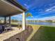 Wide lake view from the covered outdoor patio featuring blue skies and manicured grounds at 3704 Wild Blossom Pl, Parrish, FL 34219