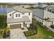 Beautiful two-story home with a gray tiled roof, brick driveway, and well-maintained landscaping at 3704 Wild Blossom Pl, Parrish, FL 34219