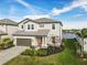 Stunning two-story home featuring a brick driveway, manicured lawn, and view of the lake at 3704 Wild Blossom Pl, Parrish, FL 34219