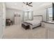 Light-filled main bedroom with tray ceiling, ceiling fan, and stylish furniture at 3704 Wild Blossom Pl, Parrish, FL 34219