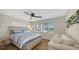 Comfortable bedroom featuring hardwood floors, ceiling fan, and a cozy seating area at 3858 Casey Key, Nokomis, FL 34275