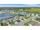 Aerial view of the community with pond, showcasing houses with manicured lawns and a distant open field at 452 Tierra Verde Way, Bradenton, FL 34212