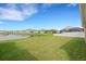 A lush green backyard is seen overlooking a serene pond, complete with a classic white fence at 452 Tierra Verde Way, Bradenton, FL 34212