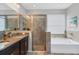 Bathroom featuring a soaking tub, frameless shower, and granite countertop at 452 Tierra Verde Way, Bradenton, FL 34212