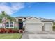 Home exterior showcasing a two-car garage, stone accents, dark front door, and lush landscaping at 452 Tierra Verde Way, Bradenton, FL 34212