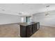 Open kitchen features granite counters, dark cabinets, an island with a sink, and an adjacent living area at 452 Tierra Verde Way, Bradenton, FL 34212