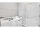 Bright laundry room with modern appliances, shelving, and a white door at 452 Tierra Verde Way, Bradenton, FL 34212