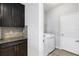 Convenient laundry room with washer, dryer, storage cabinets, and tiled backsplash at 452 Tierra Verde Way, Bradenton, FL 34212