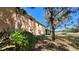 Side exterior of the building with lush landscaping and a view of a green field at 5649 Key Largo Ct, Bradenton, FL 34203