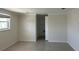 Neutral bedroom with tile flooring, a window, and an open doorway to an en-suite bathroom or closet at 618 Jungle Queen Way, Longboat Key, FL 34228