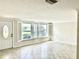 Bright living room featuring tile flooring, large windows with shutters, and a front door with an oval window at 618 Jungle Queen Way, Longboat Key, FL 34228