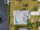 Aerial view of a home featuring a screened pool and spacious backyard, with waterfront canal access at 9008 Allapata Ln, Venice, FL 34293