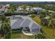 Aerial view of a charming home with a screened-in pool and waterfront access with lush landscaping at 9008 Allapata Ln, Venice, FL 34293