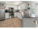 Bright kitchen with stainless steel appliances, granite countertops, tile flooring, and tray ceiling at 9008 Allapata Ln, Venice, FL 34293