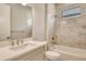 Clean bathroom featuring shower-tub combo, white vanity, and tiled walls at 10612 Nicklaus Ct, Englewood, FL 34223