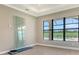 Bedroom features neutral walls, tile floors, and large windows showcasing natural light and a view of the golf course at 10612 Nicklaus Ct, Englewood, FL 34223