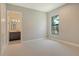 Neutral bedroom with ensuite bathroom and a large window overlooking the backyard at 10612 Nicklaus Ct, Englewood, FL 34223