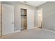 This bedroom has a walk-in closet and two entrances with neutral carpet flooring at 10612 Nicklaus Ct, Englewood, FL 34223