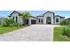 Beautiful single Gathering home boasts a paver driveway, two car garage, manicured lawn, and a tile roof at 10612 Nicklaus Ct, Englewood, FL 34223