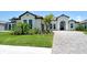 Well-manicured lawn and landscaping accentuates the exterior of this elegant single Gathering home at 10612 Nicklaus Ct, Englewood, FL 34223