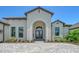 The entryway of this home features a paver walkway, manicured landscaping, and a beautiful arched entryway at 10612 Nicklaus Ct, Englewood, FL 34223