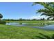 Scenic view of the golf course with lush greenery, scattered trees, and a clear blue sky above at 10612 Nicklaus Ct, Englewood, FL 34223