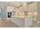Bright kitchen boasts white cabinets, stainless appliances, expansive island, and pendant lighting at 10612 Nicklaus Ct, Englewood, FL 34223