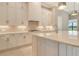 This kitchen boasts an island with quartz countertops, a gas range, and tile backsplash at 10612 Nicklaus Ct, Englewood, FL 34223