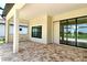 Covered patio with brick pavers, neutral paint, and large sliding doors offer a relaxing outdoor space at 10612 Nicklaus Ct, Englewood, FL 34223