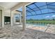 Covered patio with stone flooring overlooks the swimming pool and the golf course at 10612 Nicklaus Ct, Englewood, FL 34223