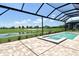 Clear swimming pool with connecting hot tub overlooks a lush green golf course at 10612 Nicklaus Ct, Englewood, FL 34223