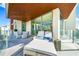 Expansive covered balcony offers modern furniture, glass railings, and beautiful cityscape views at 111 Golden Gate Pt # 401, Sarasota, FL 34236