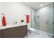 Modern bathroom with sleek vanity, toilet, and glass-enclosed shower featuring neutral color tile and modern fixtures at 111 Golden Gate Pt # 401, Sarasota, FL 34236