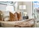 Bright bedroom features a comfortable bed with decorative pillows, a lamp, and a view of the city skyline at 111 Golden Gate Pt # 401, Sarasota, FL 34236