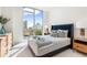Bright bedroom featuring a large window with city views, stylish decor, and modern furnishings at 111 Golden Gate Pt # 401, Sarasota, FL 34236