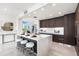 Modern open kitchen with dark wood cabinets, a large island, and adjacent living space at 111 Golden Gate Pt # 401, Sarasota, FL 34236