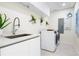 Well-lit laundry room with modern appliances, ample counter space, and cabinetry for storage at 111 Golden Gate Pt # 401, Sarasota, FL 34236