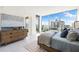 Bright main bedroom with a large bed, dresser, and a sunny window with beautiful waterfront views at 111 Golden Gate Pt # 401, Sarasota, FL 34236