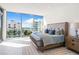 Bright, modern main bedroom with water views, floor-to-ceiling windows, and stylish, luxurious furnishings at 111 Golden Gate Pt # 401, Sarasota, FL 34236