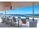 Rooftop dining with seating with overhead fan overlooking bridge and city landscape at 111 Golden Gate Pt # 401, Sarasota, FL 34236