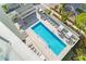 Aerial view of a large pool with surrounding lounge areas and lush landscaping at 111 Golden Gate Pt # 401, Sarasota, FL 34236