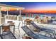 This rooftop deck features an outdoor kitchen, dining tables, lounge chairs, and sunset water views at 111 Golden Gate Pt # 401, Sarasota, FL 34236
