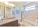 Well-lit bathroom featuring a granite vanity, mirror and tiled tub shower at 11740 Rive Isle Run, Parrish, FL 34219