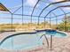 A sparkling swimming pool is surrounded by a screen enclosure, with a spa and seating area overlooking a tranquil lake at 11740 Rive Isle Run, Parrish, FL 34219