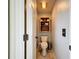 Cozy half bathroom with a modern toilet, a rustic wall shelf, and tile floors at 13710 Glossy Ibis Pl, Lakewood Ranch, FL 34202