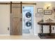 Practical laundry area concealed behind a stylish barn door at 13710 Glossy Ibis Pl, Lakewood Ranch, FL 34202