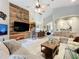 Living room with a sectional sofa and a view into the kitchen, featuring a unique wooden accent wall with a television at 13710 Glossy Ibis Pl, Lakewood Ranch, FL 34202